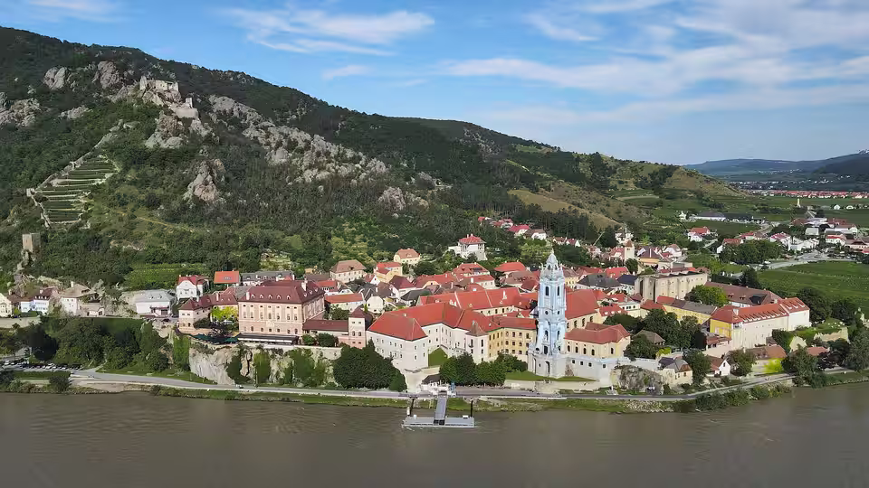 Luftaufnahme von Dürnstein mit blauem Stiftsturm, Donau und Burgruine