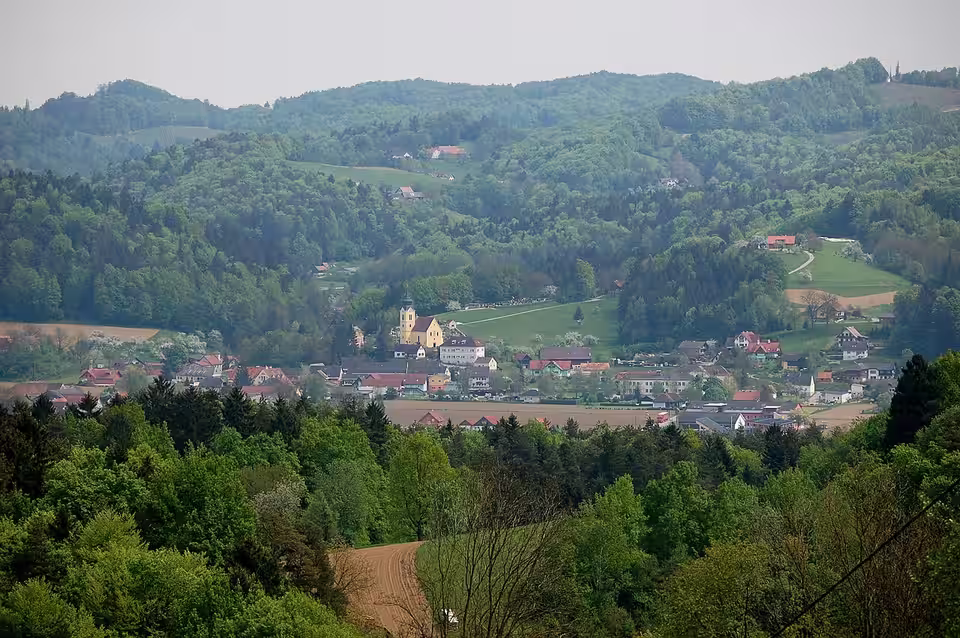 Großklein mit Kirche zwischen bewaldeten Hügeln