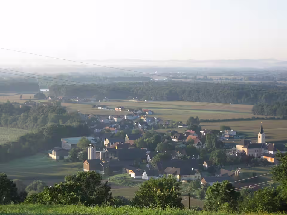 Blick auf Lang mit Kirche und Feldern in der Ebene