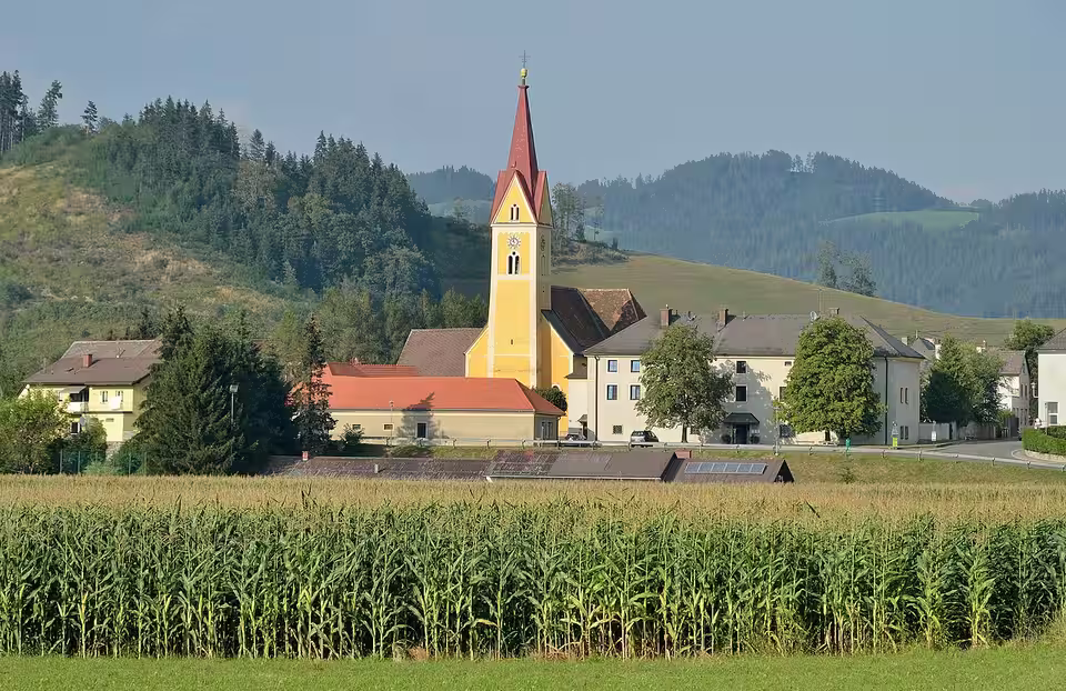Pfarrkirche und Pfarrhof von Sankt Stefan ob Leoben hinter einem Feld