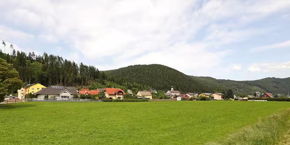 Traboch mit Häusern und Kirche hinter einer Wiese