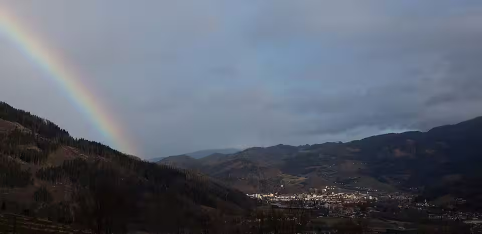 Blick auf Bruck an der Mur mit Regenbogen über dem Tal
