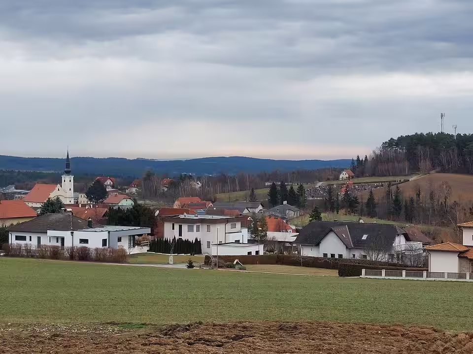Dechantskirchen mit Häusern und Kirche hinter einer Wiese