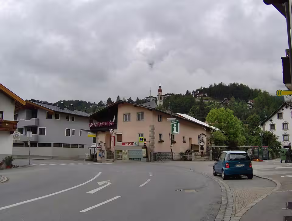 Straße durch Tarrenz mit Häusern und Kirchturm