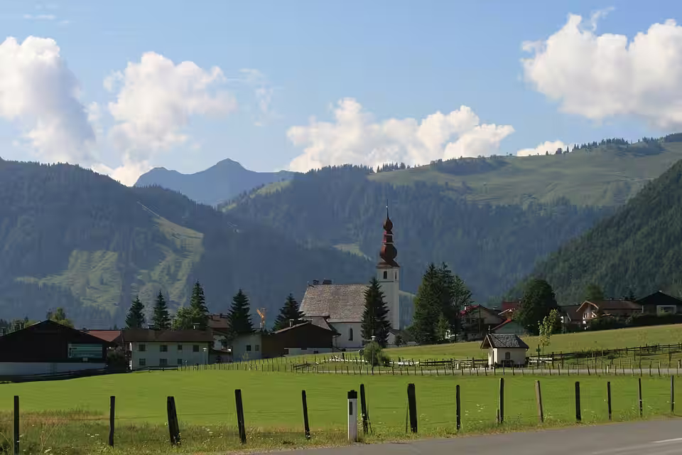 Sankt Ulrich am Pillersee mit Kirche hinter einer Wiese