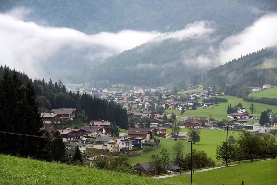 Waidring mit Häusern und Kirche bei tiefen Wolken