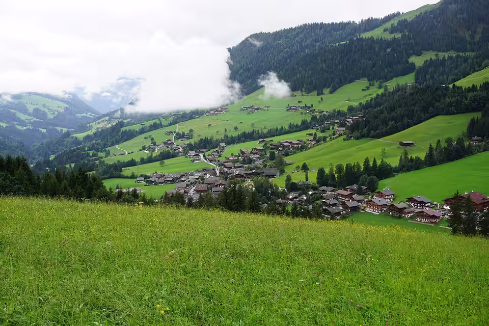 Blick auf Alpbach zwischen grünen Hängen und Wolken
