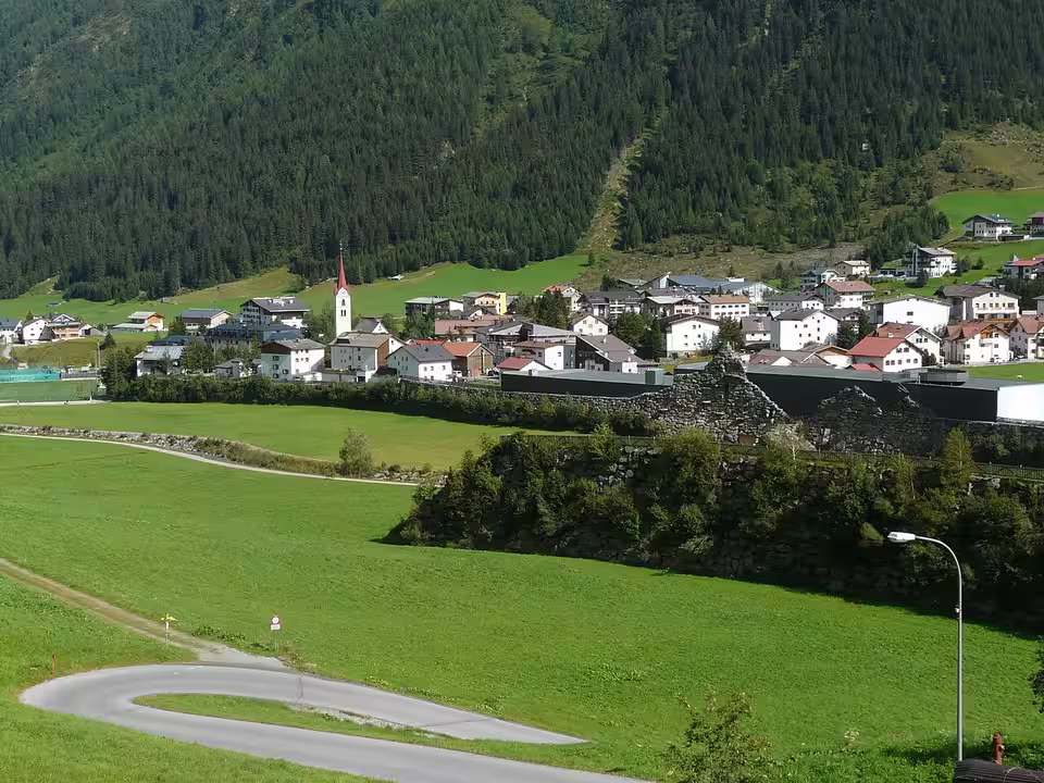 Galtür mit Kirche, Lawinenschutzmauer und Alpinarium