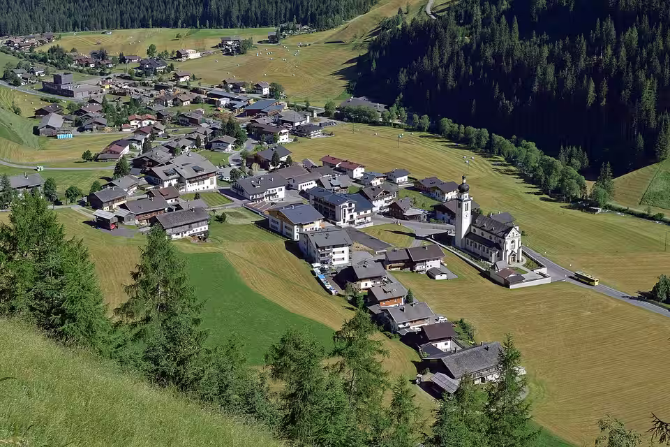 Blick auf Innervillgraten mit Häusern, Kirche und Wiesen